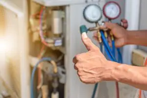 Technician giving a thumbs up while performing hvac maintenance